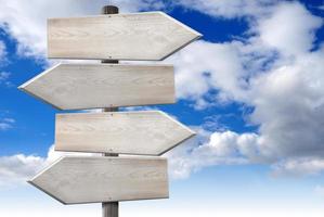 Empty Wooden Signpost with Four Arrows with Cloudy Sky in Background photo