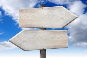 Empty Wooden Signpost with Two Arrows with Cloudy Sky in Background photo