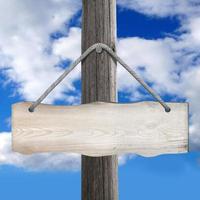 Wooden Board Hanging on Post on A Rope with Sky in Background photo