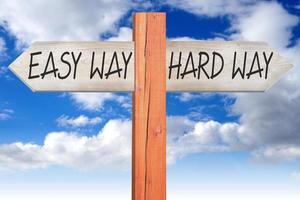 Hard or Easy Way - Wooden Signpost with Two Arrows and Cloudy Sky photo