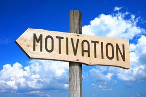 Motivation - Wooden Signpost with one Arrow, Sky with Clouds in Background photo