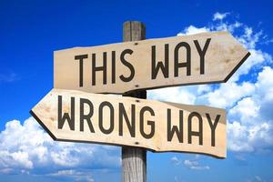 This Way, Wrong Way - Wooden Signpost with Two Arrows, Sky with Clouds in Background photo