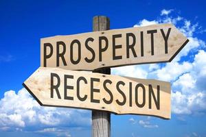 Prosperity, Recession - Wooden Signpost with Two Arrows, Sky with Clouds in Background photo