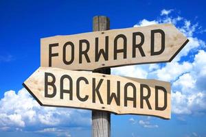 Forward, Backward - Wooden Signpost with Two Arrows, Sky with Clouds in Background photo