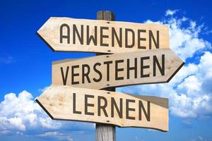 Learn, Undestand, Use in German - Wooden Signpost with Three Arrows photo