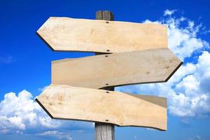 Wooden Signpost with Three Clear Arrows, Sky with Clouds in Background photo