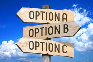 Options A, B, C - Wooden Signpost with Three Arrows, Sky with Clouds in Background photo