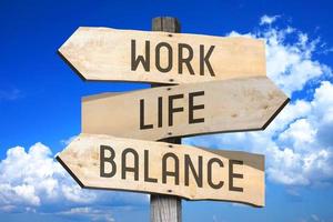 Work, Life, Balance - Wooden Signpost with Three Arrows, Sky with Clouds in Background photo