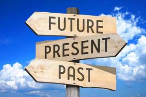 Future, Present, Past - Wooden Signpost with Three Arrows, Sky with Clouds in Background photo