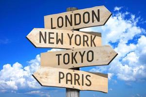 Londres, nuevo york, tokio, París - capital ciudades concepto - de madera señalizar con cuatro flechas foto