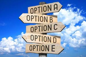 Option A, B, C, D, E - Wooden Signpost with Five Arrows, Sky with Clouds in Background photo