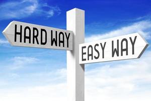 Easy Way, Hard Way - Wooden Signpost with Two Arrows and Sky in Background photo