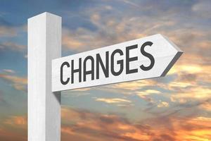 Changes Ahead - White Wooden Signpost with one Arrow and Sunset Sky in Background photo