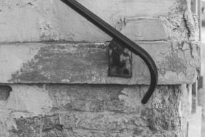 railing in front of an old house wall in black and white photo