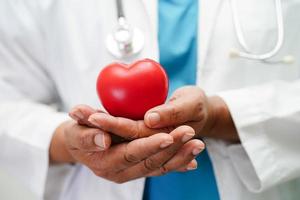 Asian woman doctor holding red heart for health in hospital. photo