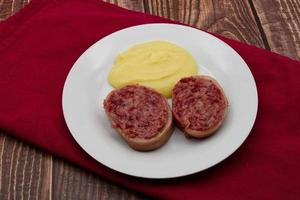 Slices of traditional Italian sausage Zampone di Modena with mashed potatoes. photo