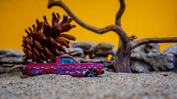 toy car hauling pinecones on an orange background photo