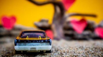 Minahasa, Indonesia  December 2022, toy car with gradient orange background and a heart photo