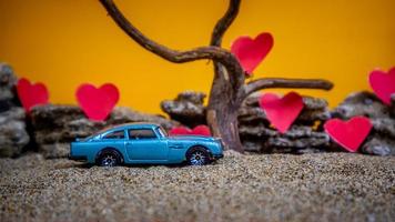 Minahasa, Indonesia  December 2022, toy car with gradient orange background and a heart photo