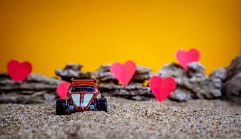 Minahasa, Indonesia  December 2022, toy car with gradient orange background and a heart photo