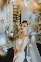 The charming bride is standing in the hotel's lobby near the chandelier photo