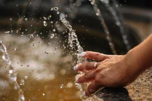 Hands with water splash, backlit by the evening sun. photo