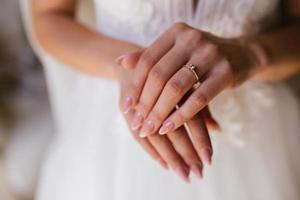 Gold wedding rings are on the bride's hand photo