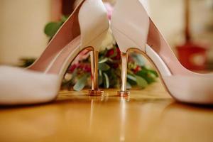 Wedding rings lie on white shoes. photo