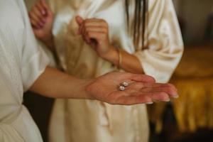 Gold wedding rings are on the bride's hand photo