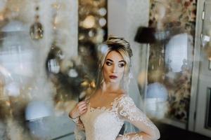 The charming bride is standing in the hotel's lobby near the chandelier photo