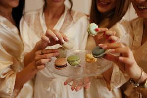 Girl holding colorful French macarons in hands photo