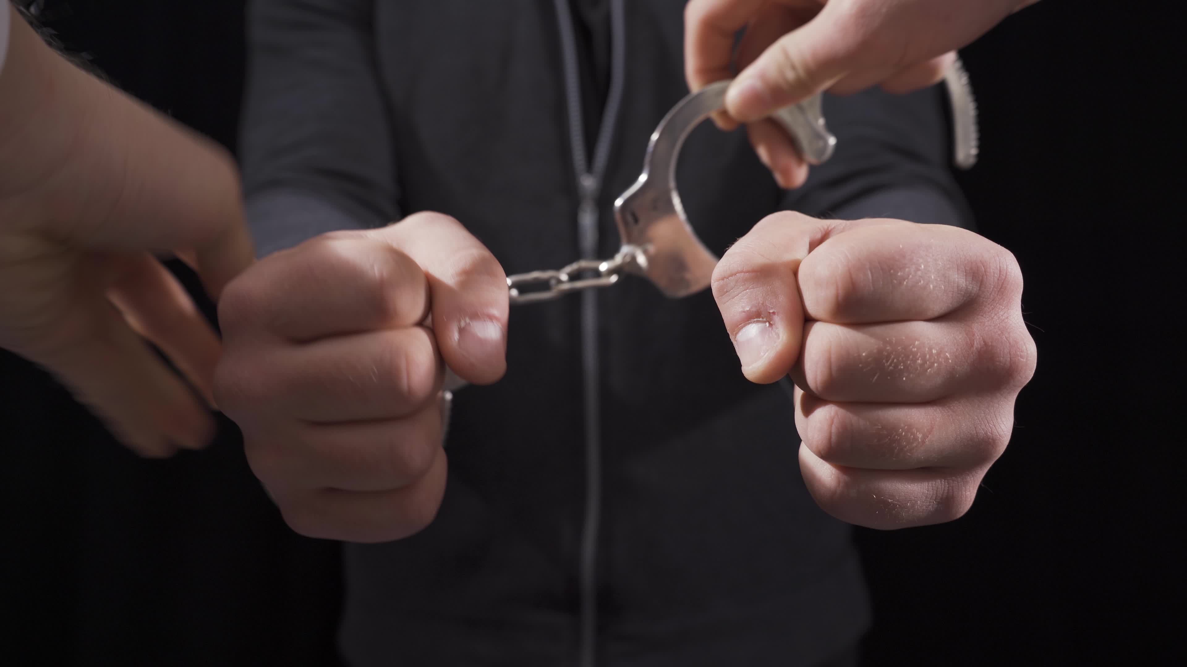 Handcuffing the criminal. Handcuffing the guilty man. 21635598 Stock