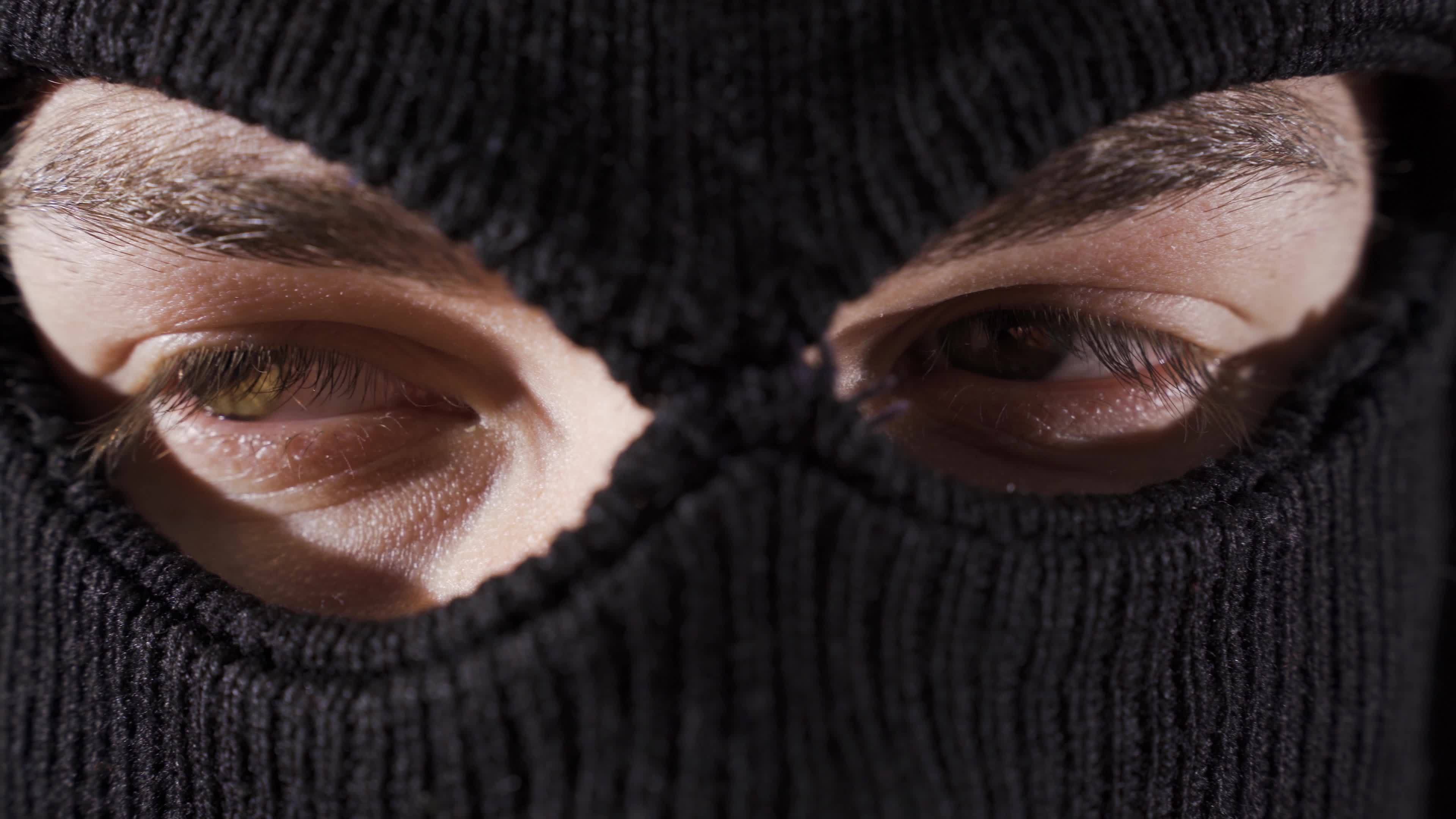 Closeup masked assassin, soldier or thief. Closeup of man in ski mask