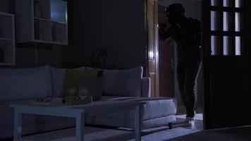 voleur homme vol à Accueil avec lampe de poche. Masculin voleur pauses dans maison et engage vol. video