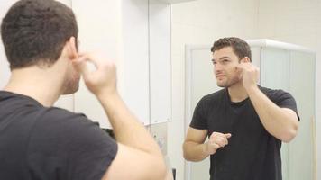 de man vem räcker ut hans hår i de spegel finner han själv stilig. karismatisk man ser på han själv i de spegel. video