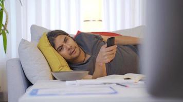 Lazy bored man lying on sofa and watching tv. Bored lazy man watching tv. video