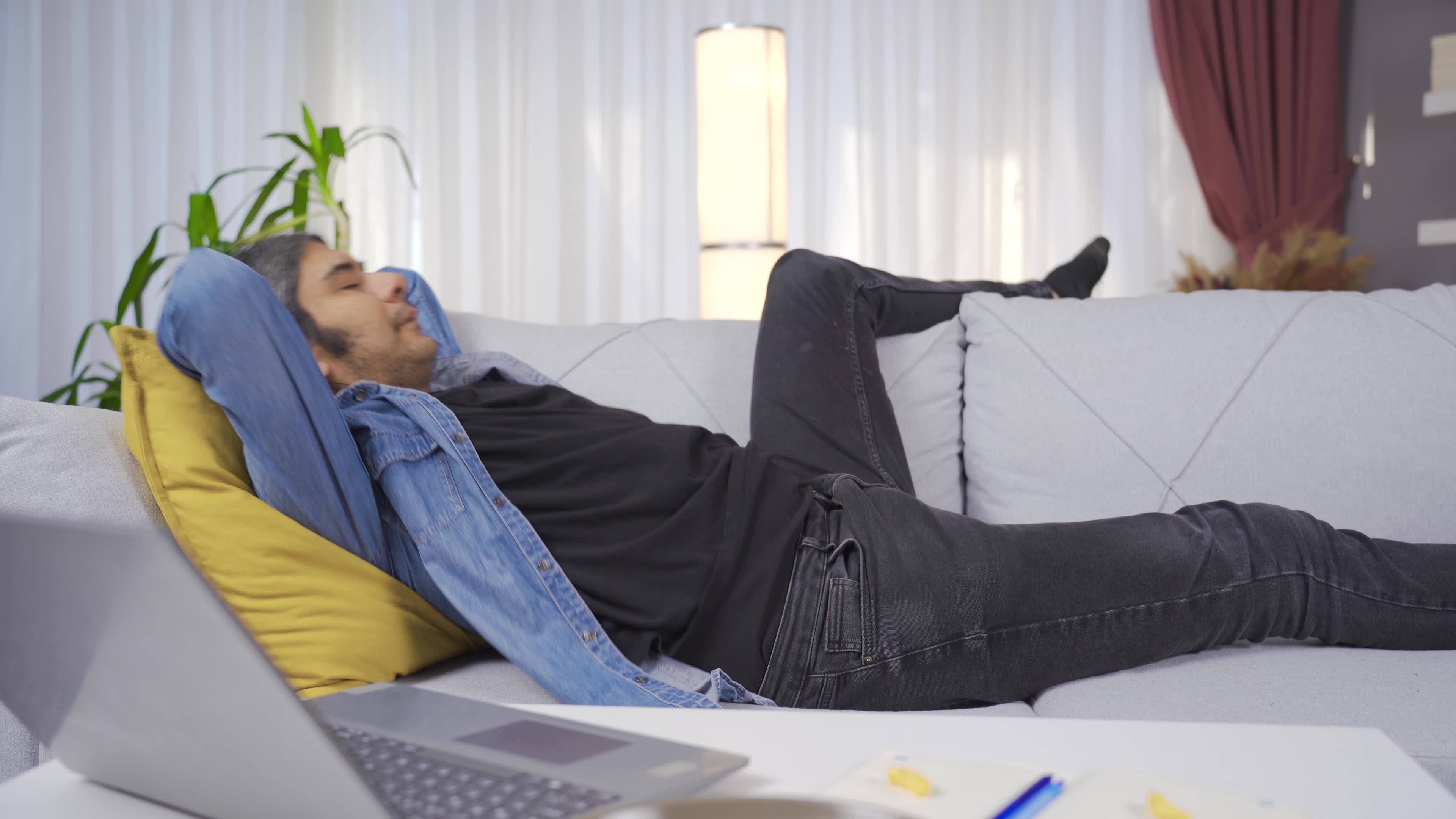 Tired man came home after work, threw himself on the sofa. The lazy man