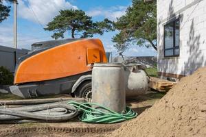 máquina con mezclador esinstalacion para alimentación cemento mezcla para torrencial semi seco piso maestra en casa. construcción sitio con diapositiva de arena, preparación para arrasamiento el áspero piso de cabaña foto