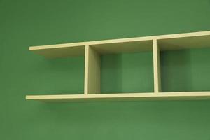 Wooden shelf installed on green wall photo