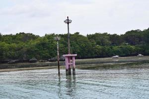 Lighthouse Mast against blue sky with white clouds near harbour, Indonesia. photo