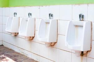 line of white porcelain urinals in public toilets, dirty toilets outdoor photo