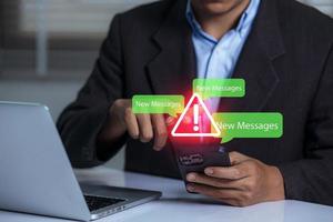 Businessman using smartphone with new message electronic email hacking and spam warning symbol. cyber attack network, virus, spyware, Cyber security and cybercrime. photo