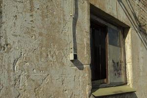 Window in old building. Industrial zone. Paint-free wall. photo