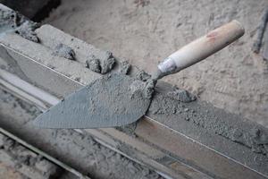 selectively focus on the dirty cement spoon because it is used to install bricks, in Indonesian the cement spoon is called cetok, soft focus photo