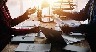 Group of confident business people point to graphs and charts to analyze market data, balance sheet, account, net profit to plan new sales strategies to increase production capacity. photo