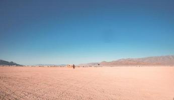 personas caminando hacia puesta de sol a un festival en el Desierto a el ardiente hombre festival. foto