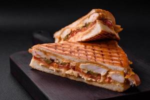 Delicious crispy sandwich with chicken breast, tomatoes, ketchup and spices photo