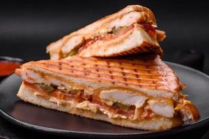 Delicious crispy sandwich with chicken breast, tomatoes, ketchup and spices photo