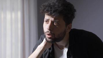 giovane uomo con mentale malattia è a casa. pazzo uomo. un' disturbato uomo con sintomi di schizofrenia. avendo un' mentale disturbo. video