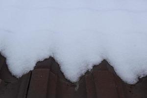 fresh snow on a dark roof photo